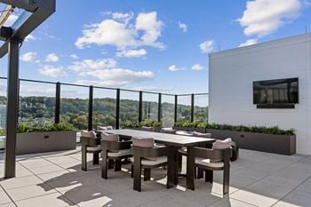 A terrace with a table and chairs and a view of the city