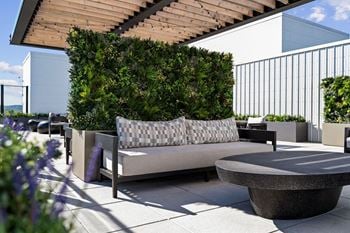 A modern outdoor seating area with a bench and a table