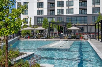 A large swimming pool in front of a multi-story building