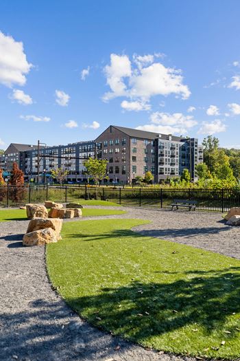 A park with a grassy area and a building in the background