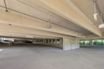 A parking garage with concrete pillars and a concrete floor