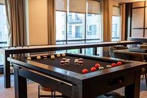 Newtown Square apartment for rent - A game room with a shuffleboard table and couches at The Harrison.