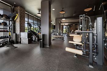 A gym with weights and exercise equipment on the floor and a window