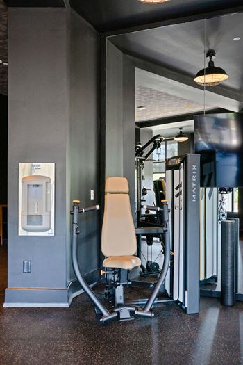 A gym with a weight machine and a treadmill