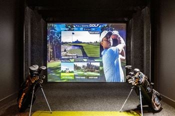 A display of golf equipment in front of a tv screen