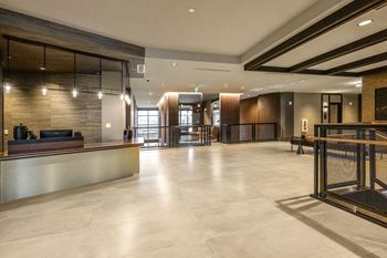 A spacious lobby with a reception desk and a large glass door
