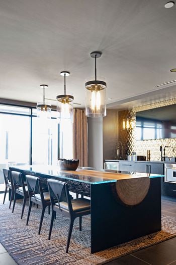 A modern kitchen with a long table and chairs