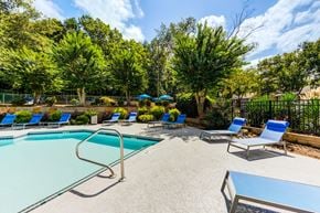 Raleigh apartment for rent - A pool with lounge chairs and pool house at Laurel Oaks in Raleigh, NC.