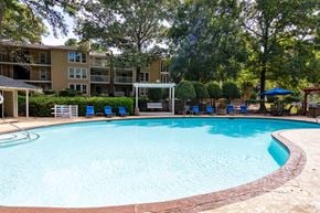 Raleigh apartment for rent - A swimming pool surrounded by trees and apartment buildings.