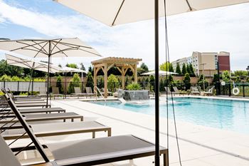 A pool with lounge chairs and umbrellas