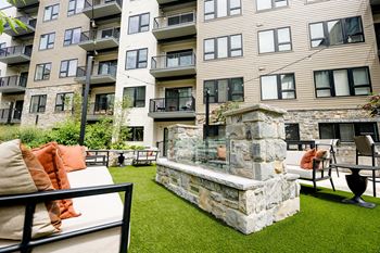 An outdoor seating area with a fireplace at the bradley braddock road station apartments
