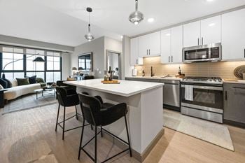 An open kitchen and living room with a white counter top