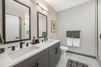 A bathroom with two sinks and a toilet