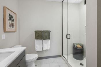 A bathroom with a toilet, sink, and shower
