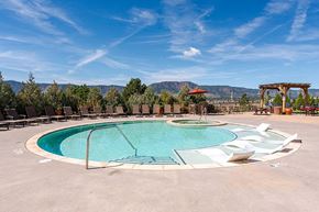 Monument apartment for rent - A large outdoor swimming pool surrounded by lounge chairs and trees at Vistas at Jackson Creek, Monument