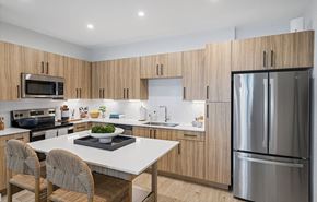 Orlando apartment for rent - a kitchen with wooden cabinets and stainless steel appliances at Madison Waterford Lakes, Florida, 32826