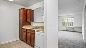 Ellicott City apartment for rent - A kitchen with wooden cabinets and a white dishwasher.