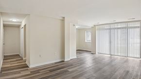 Washington apartment for rent - A spacious room with wooden flooring and white walls.