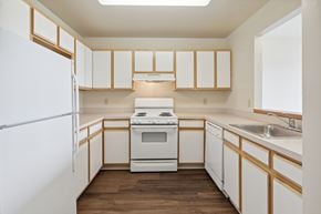 Baltimore apartment for rent - A kitchen with white appliances and wooden cabinets.