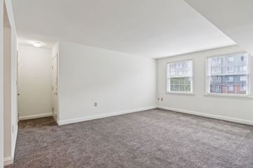 Towson apartment for rent - Living room in Towson senior apartment with two windows and neutral carpet