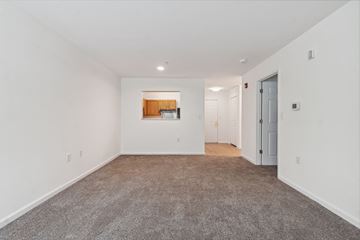Columbia apartment for rent - a living room with carpet and white walls and a door to a kitchen