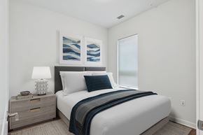 Baltimore apartment for rent - A bedroom with a bed, nightstand, and artwork on the wall.