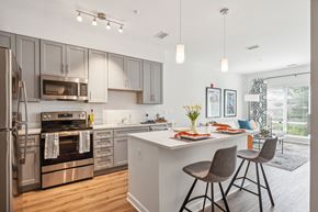 Columbia apartment for rent - Model kitchen with stainless steel appliances and an island with stools at Legacy at Twin Rivers