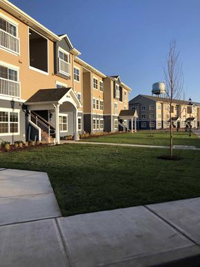 Princess Anne apartment for rent - an exterior view of a row of apartments with grass and a sidewalk