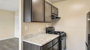 Washington apartment for rent - A kitchen with a black stove top oven and a counter top with a granite counter top.