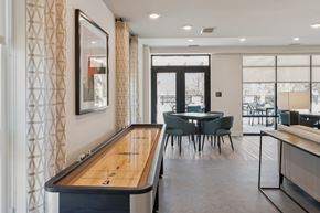 Baltimore apartment for rent - A shiny pool table with numbers 1-8 on it is in the middle of a room with a mirror and curtains.