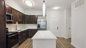 Baltimore apartment for rent - A kitchen with dark brown cabinets and a white island.