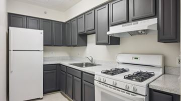 Washington apartment for rent - A white refrigerator sits in a kitchen with dark grey cabinets.