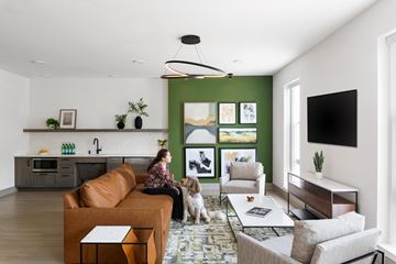 Silver Spring apartment for rent - A woman is sitting on a couch with a dog in a living room.