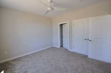 Owings Mills apartment for rent - a bedroom with white doors and a ceiling fan