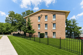 Washington apartment for rent - A brick building with a black fence in front.