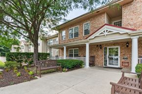 Baltimore apartment for rent - A brick house with a porch and a tree in front.