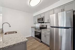 La Plata apartment for rent - A modern kitchen with a stainless steel refrigerator and a granite countertop.