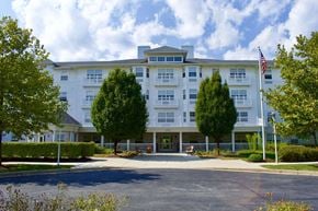 Middle River apartment for rent - Front of Park View at Miramar Landing with a flag swaying in the wind and trees in abundance