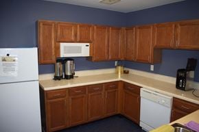 Middle River apartment for rent - Spacious community kitchen fully equipped with a white refrigerator, dishwasher, microwave, and small appliances.