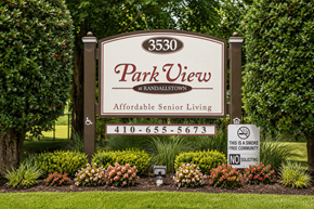 Randallstown apartment for rent - A sign for Park View at Randalstown, an affordable senior living community, is displayed in front of a green hedge.