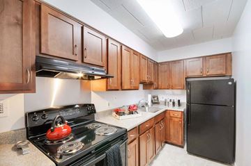 Washington apartment for rent - a kitchen with black appliances and wooden cabinets