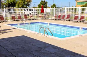 Edgewood apartment for rent - a swimming pool with chairs around it next to a fence