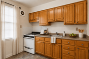 Towson apartment for rent - A kitchen with wooden cabinets and a white stove.