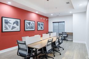 Columbia apartment for rent - a conference room with a long wooden table and chairs and a red accent wall