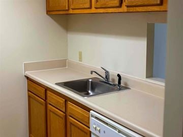 Annapolis apartment for rent - a kitchen with a sink and a dishwasher and wooden cabinets