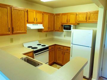 Dundalk apartment for rent - a kitchen with white appliances and wooden cabinets