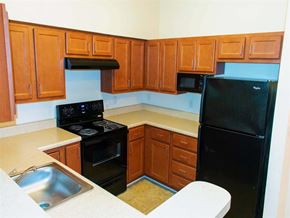 Dundalk apartment for rent - an empty kitchen with black appliances and wooden cabinets