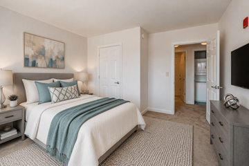 Washington apartment for rent - A bedroom with a bed, nightstand, and a painting on the wall.