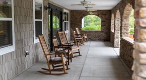 Catonsville apartment for rent - A row of wooden rocking chairs are lined up on a porch.