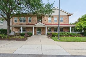 Baltimore apartment for rent - A two-story brick house with a front porch.